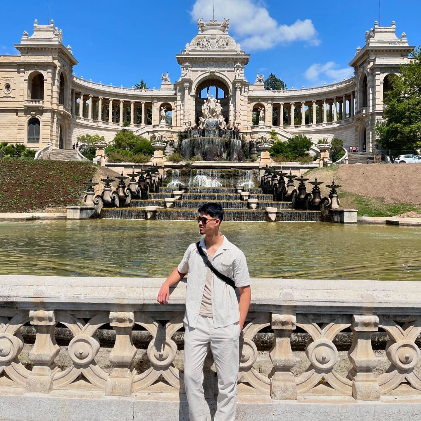Imaad in front of an ornate palace with a fountain in Marseille